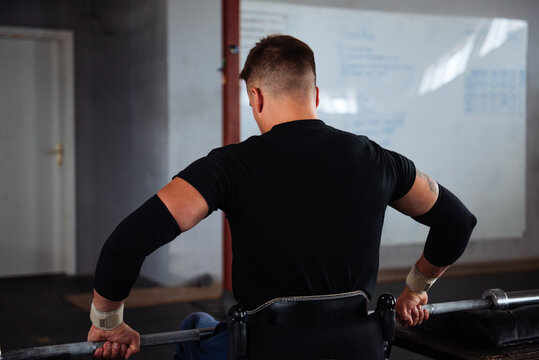 Wheelchair Athlete Lifting Weights In Gym Training