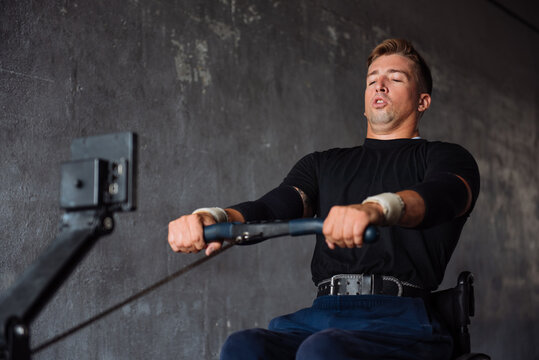 Wheelchair Athlete Performing Rowing Workout In Gym