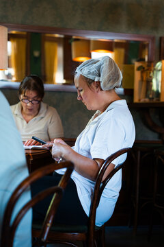 Restaurant Worker Using a Smartphone at a Table