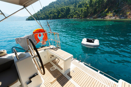 Dinghy Floating Beside Anchored Sailing Yacht
