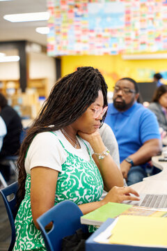 Focused teacher working on laptop
