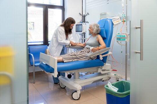 Nurse supporting senior patient during medical infusion
