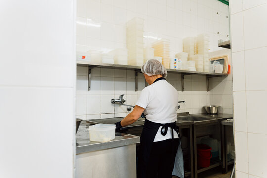 Kitchen Worker Washing Trays in a Commercial Kitchen