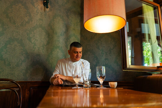 Chef Reading a Menu at a Restaurant Table