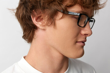 Young man in glasses profile portrait. Studio shot on white background. Concept for smart modern style, vision correction, or education. © SHOTPRIME STUDIO