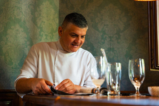Chef Reading a Menu at a Restaurant Table