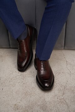 Brown shoes worn with blue suit in indoor setting