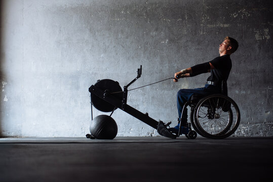 Wheelchair Athlete Training on Rowing Machine in Gym