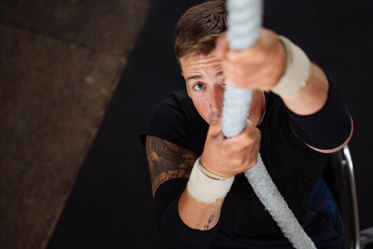 Wheelchair Athlete Climbing Rope in Gym Showing Determination