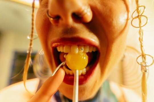 Biting Into Yellow Lollipop