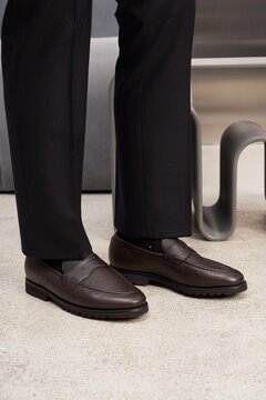 Brown shoes worn with black pants in modern setting