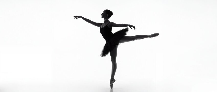Silhouette of a graceful ballerina dancing in a tutu against a white background