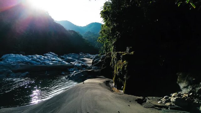 Sunlit Rocky River Canyon in Tropical Ecuador with Forested Cliffs, Sandy Bank, Lens Flare, Mountain Valley and Remote Andean Amazon Landscape