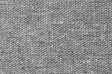 Gray woven fabric closeup. Coarse textile fibers and threads. Neutral upholstery material surface....