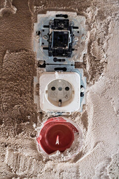 Closeup damaged wall outlets with exposed wiring, plaster debris views