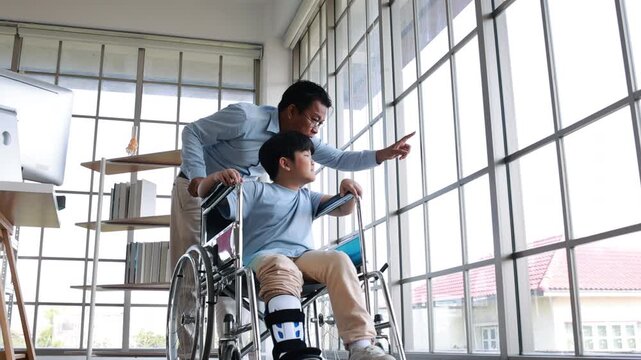 orthopedic walking, Crutches Walks Confidently. Child Step in Rehabilitation with Leg Brace. Asian father helping to support his son, who has a broken ankle