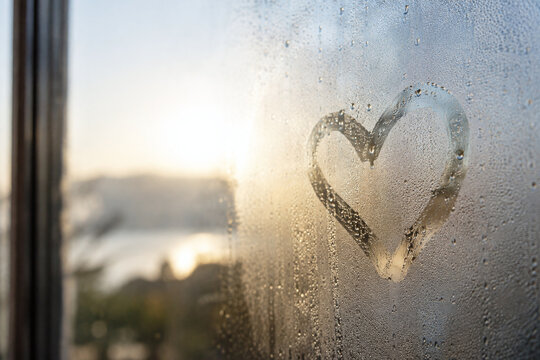 Heart Drawn in Condensation on Sunlit Window
