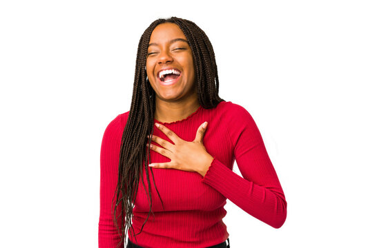 Young African American woman laughing out loudly while keeping her hand on her chest, isolated on a white background