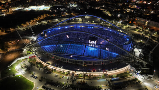 Aerial drone scenic view of live concert illuminated with colorful lights of Anna Vissi popular Greek singer in OAKA sports stadium designed by Santiago Calatrava, Athens, Greece