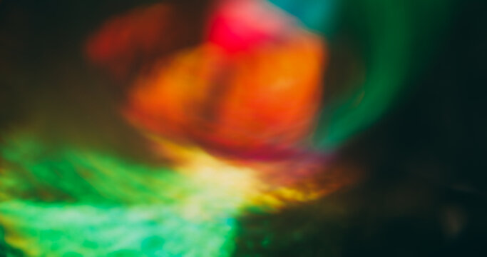 Blur optical glow. Radiant light. Defocused warm orange blue pink color glisten luminous visual glimmer flash on abstract bokeh dark black art background.