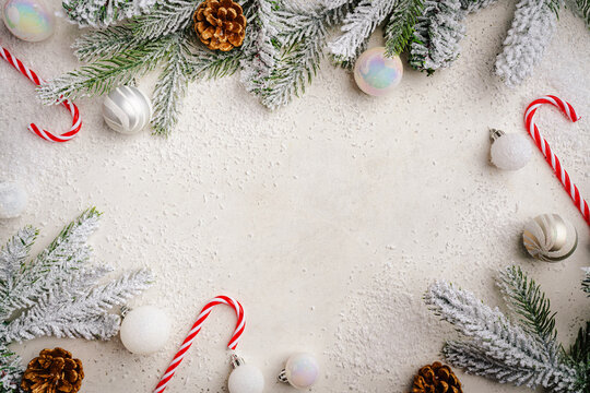 Christmas and New Year background with fir branches with holiday decorations and pine cones on a white table, banner for holiday screen, template for design. Holiday card