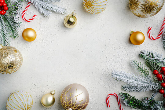 Christmas and New Year background with fir branches with gold holiday decorations and pine cones on a white table, banner for holiday screen, template for design. Holiday card