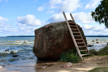 giant glacial erratic boulder with a wooden ladder on Käsmu beach in Estonia © eve