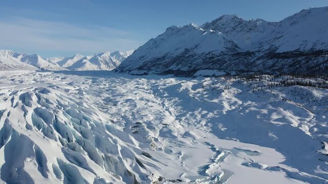 Panoramic View of Frozen Glacier Snowfield Below Sunlit Polar Mountain Range