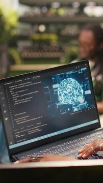 Young woman coding ai software on laptop in sunny day