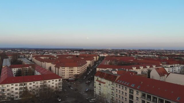 Aerial view of a city neighborhood with red roofs at dusk