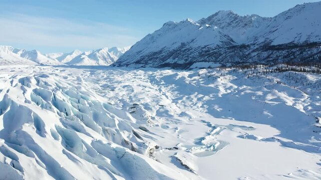 Panoramic View of Frozen Glacier Snowfield Below Sunlit Polar Mountain Range