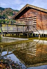 Fototapeta premium Wooden cabin with logs near green field and trees on sunny day in countryside