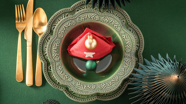 Bottle green Christmas table decorated with colorful baubles.