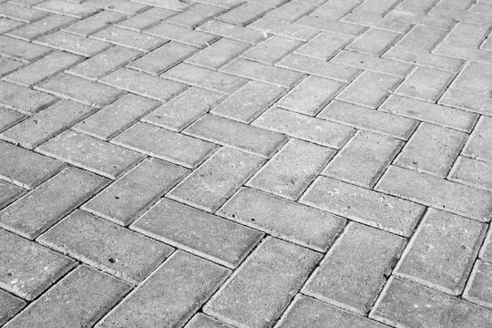 Durable grey interlocking pavers form a precise herringbone pattern. 