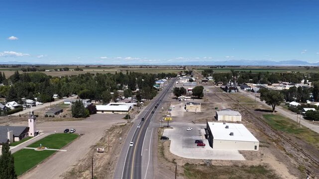 Aerial of a rural highway 285 and small town buildings with mountains in the distance overlooking La Jara Colorado
