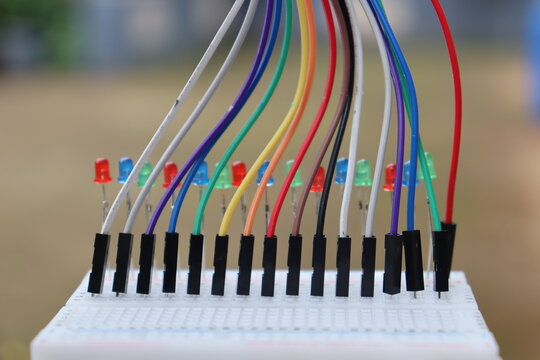 Colorful jumper wires connected to a breadboard with LEDs for electronics prototyping