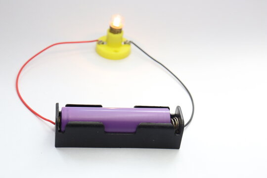 Incandescent bulb glowing connected to a battery holder with lithium ion battery
