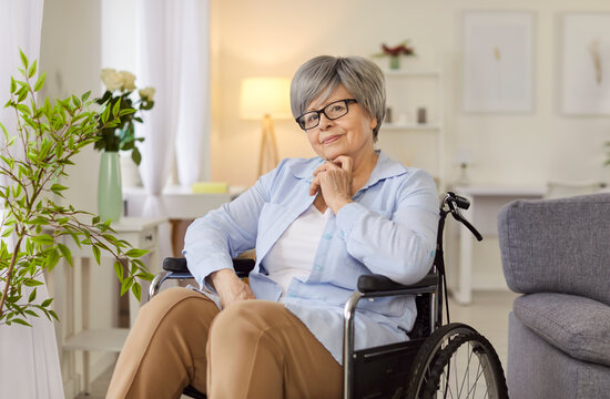 Pleasant old senior woman handicapped lady patient sitting in wheelchair, female grandma, elderly healthcare, parkinson disease, equipment for geriatric medical care, support 
