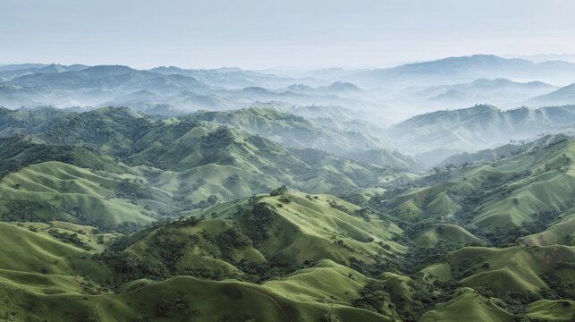 Serene misty mountain range with rolling green hills and lush vegetation