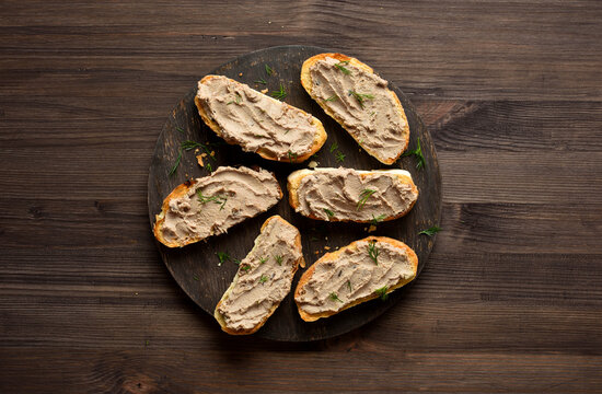 Appetizer liver pate on toasted bread on cutting board