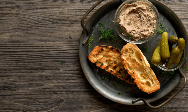 Liver pate served with toasted bread and marinated cucumber