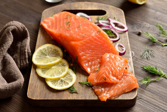 Fresh salted salmon with spices on cutting board