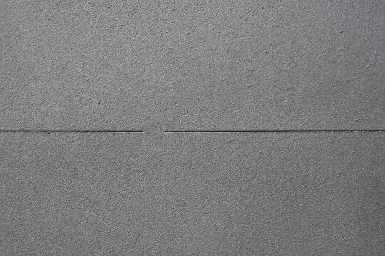 Gray textured wall with narrow horizontal groove and copy space