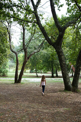 Fototapeta premium Young girl walking through natural park exploring outdoors