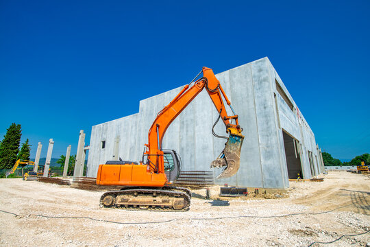 Heavy excavator working in active construction zone for new residential complex development