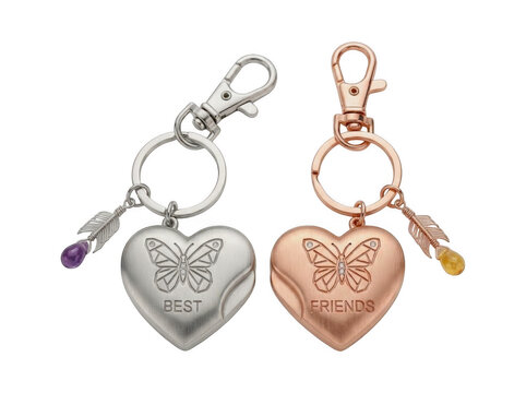 Two heartshaped keychains with butterfly engravings and crystal charms, one silver and one rose gold, isolated on white isolated on transparent background