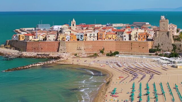 Cinematic drone 4k Termoli Old Town aerial 70mm view Castello Svevo Molise Italy colorful pastel houses on promontory over turquoise Adriatic Sea beach and medieval castle walls drone B-roll