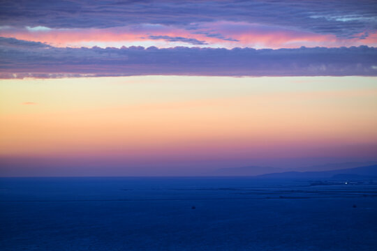 Pastel sunset over ocean with layered clouds