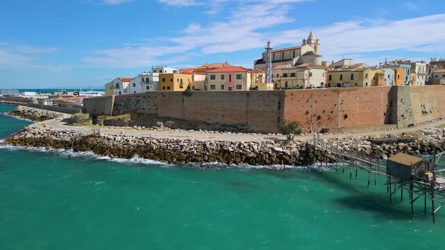Termoli Old Town drone view Trabucco on stilts Molise Italy Castello Svevo aerial pan over turquoise sea with colorful pastel houses and medieval walls cinematic B-roll. Italian hidden gems