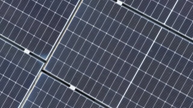 Video showing a bird's-eye view of modern solar panels installed on a roof as part of a sustainable energy production system